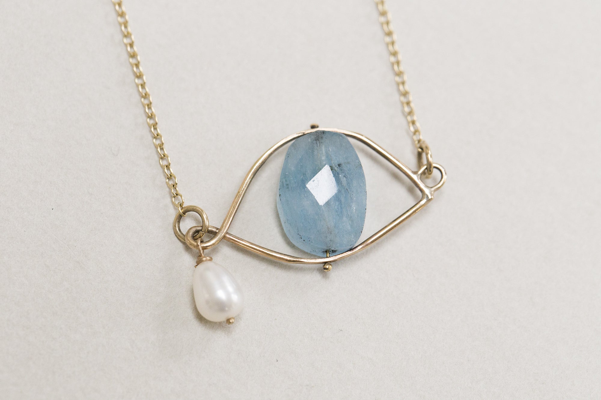 Claire van Holthe faceted aquamarine bead eye necklace with freshwater pearl teardrop set in 9 carat gold eye wire frame 