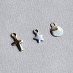 from left: gold plated cross, sterling silver star and 18 carat yellow gold disc