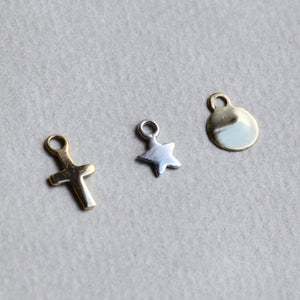 from left: gold plated cross, sterling silver star and 18 carat yellow gold disc