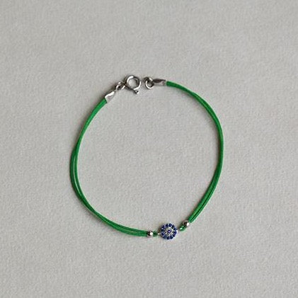 close up of the hot pink and grass green evil eye sterling silver bracelets