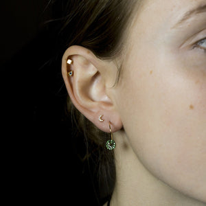 Ella wears wonky hoops with tsavorite discs, Tai crescent stud, felt's gold cube stud and Tai eye earring, all available at feltlondon.com