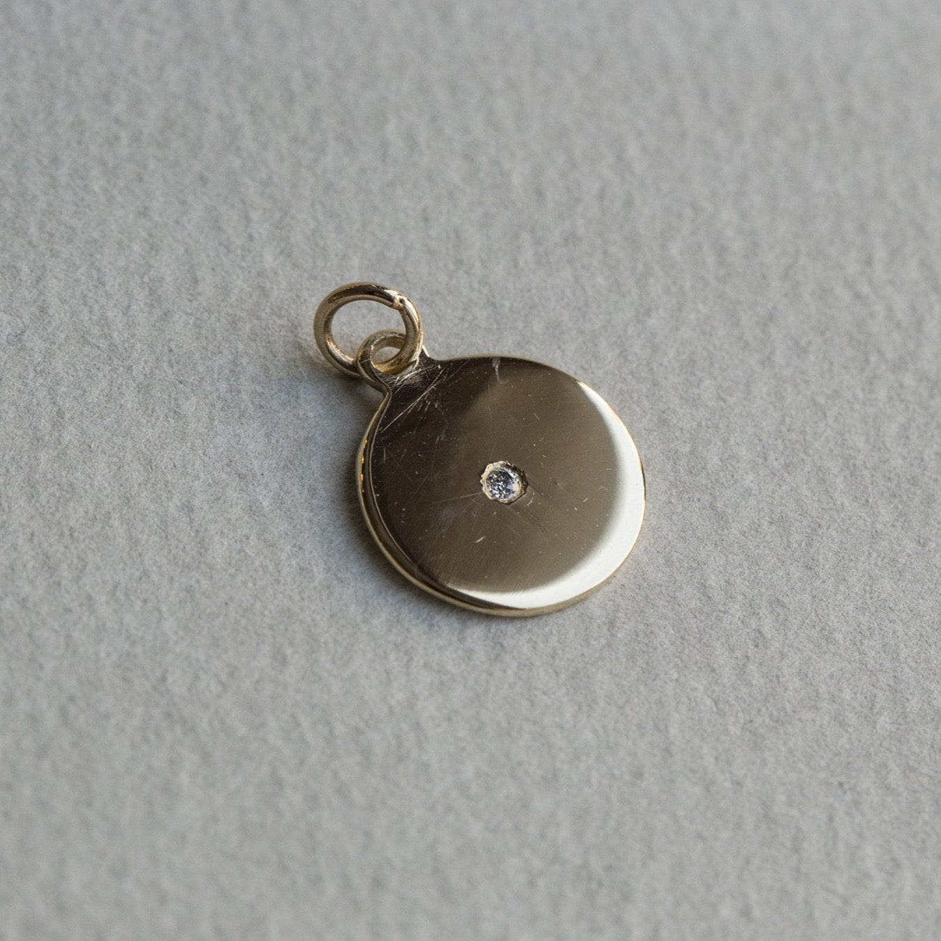felt's own design - incredibly simple and enchanting polished gold disc with diamond