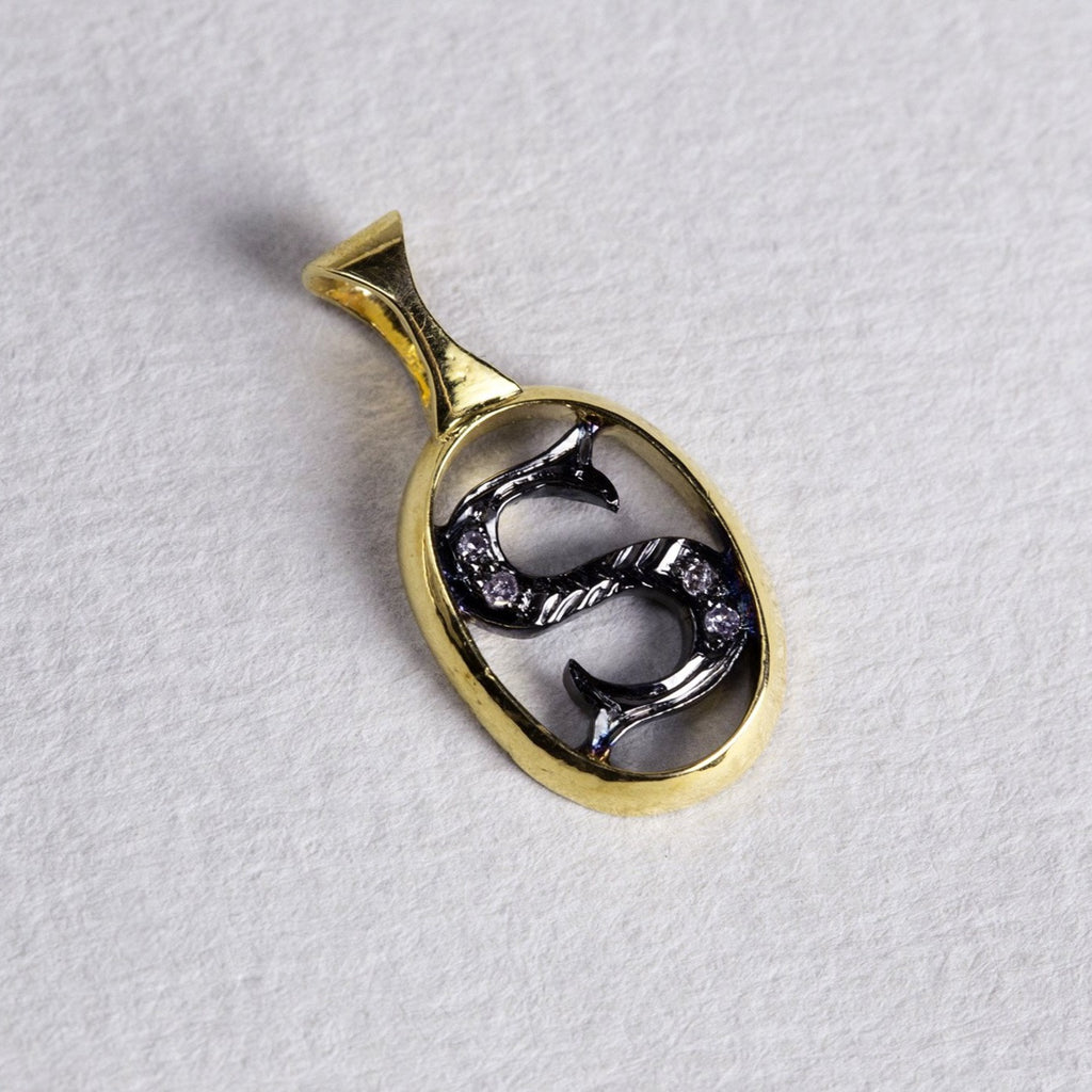 the initial pendants are made of gold, oxidised silver and diamonds 
