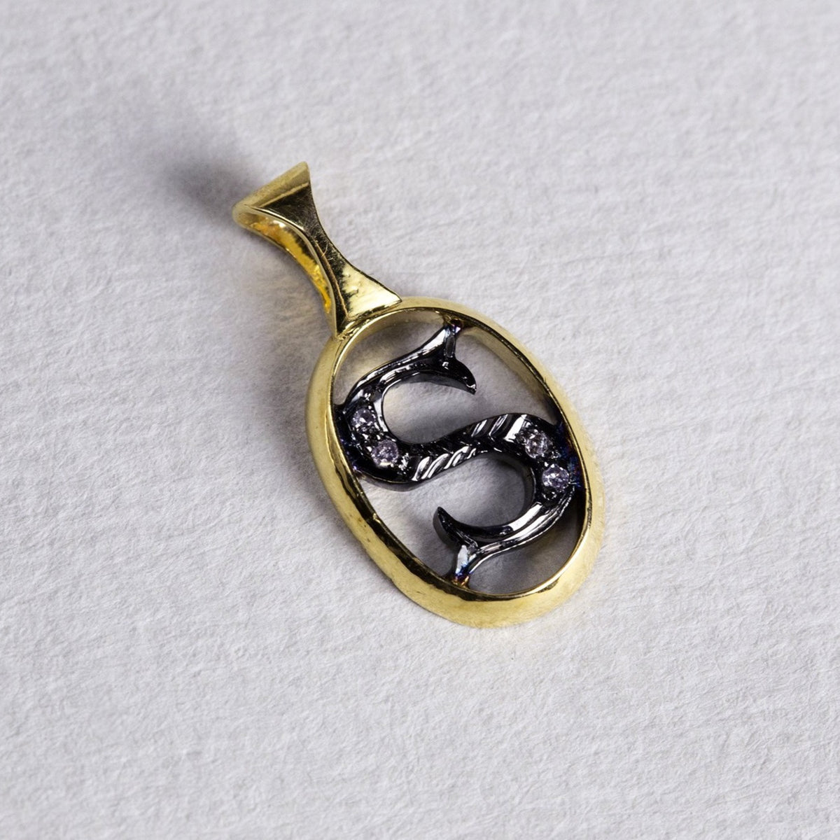 the initial pendants are made of gold, oxidised silver and diamonds 